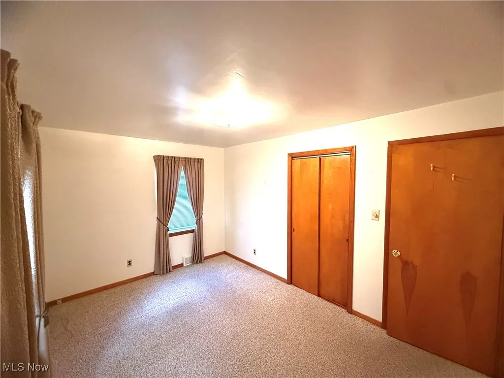 Unfurnished bedroom featuring carpet and a closet