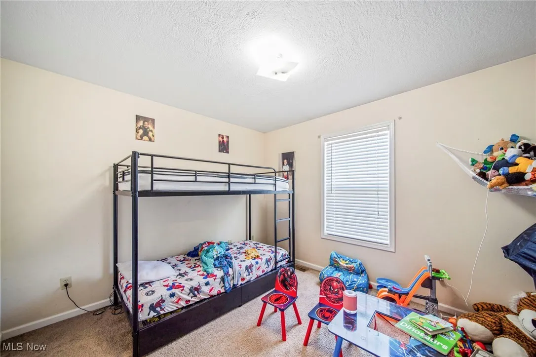 Bedroom featuring carpet flooring and a textured ceiling