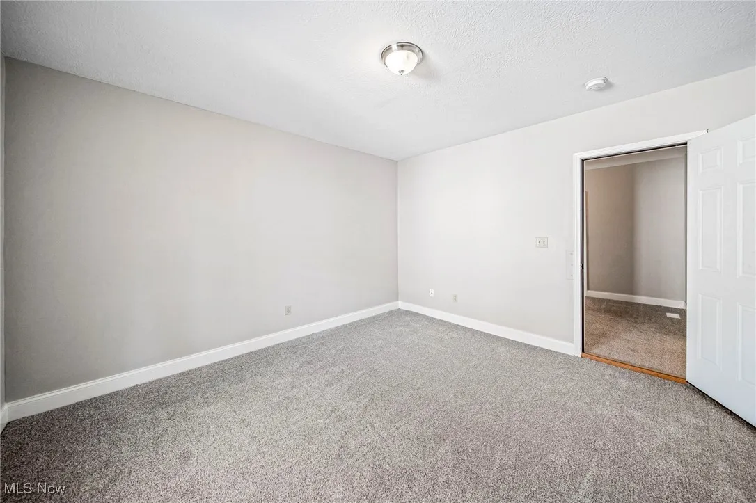 Unfurnished bedroom featuring carpet floors and a textured ceiling