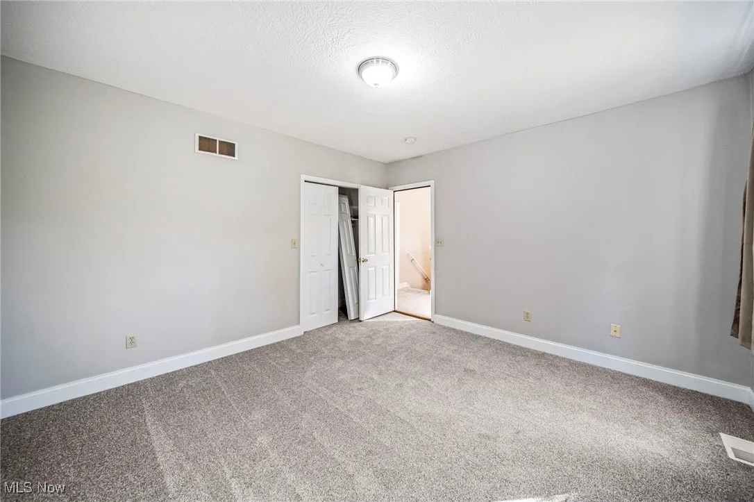 Unfurnished bedroom with carpet floors, a closet, and a textured ceiling