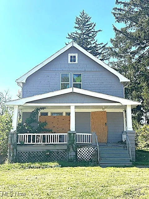 Rear view of property featuring a porch and a lawn