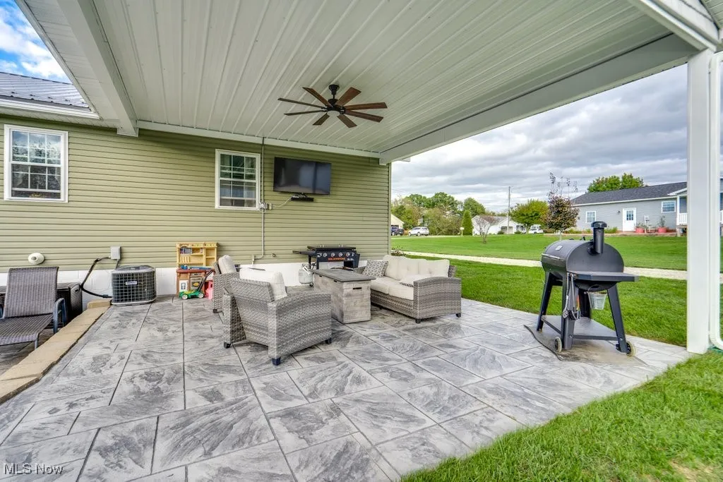 View of patio with ceiling fan, an outdoor living space, and grilling area