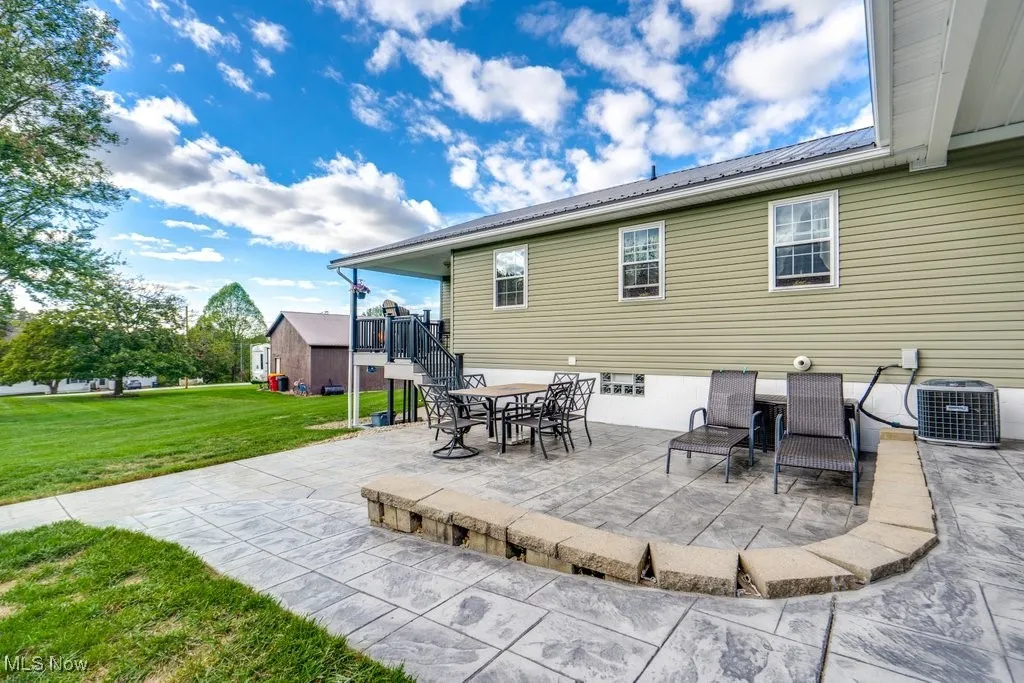 View of patio featuring stairway and outdoor dining area