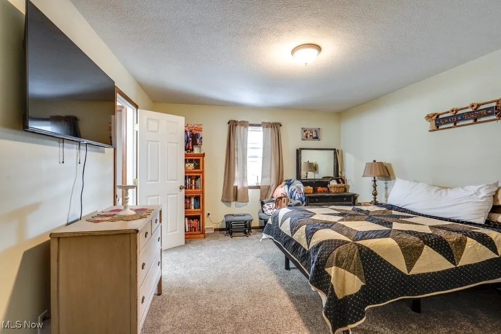 Bedroom with light carpet and a textured ceiling