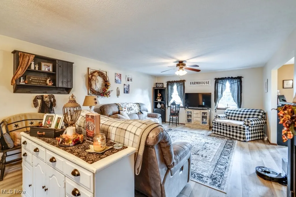 Living room with light wood-style floors and ceiling fan