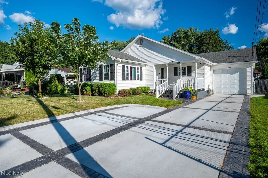 Ranch-style house with concrete driveway, covered porch, an attached garage, and a shingled roof