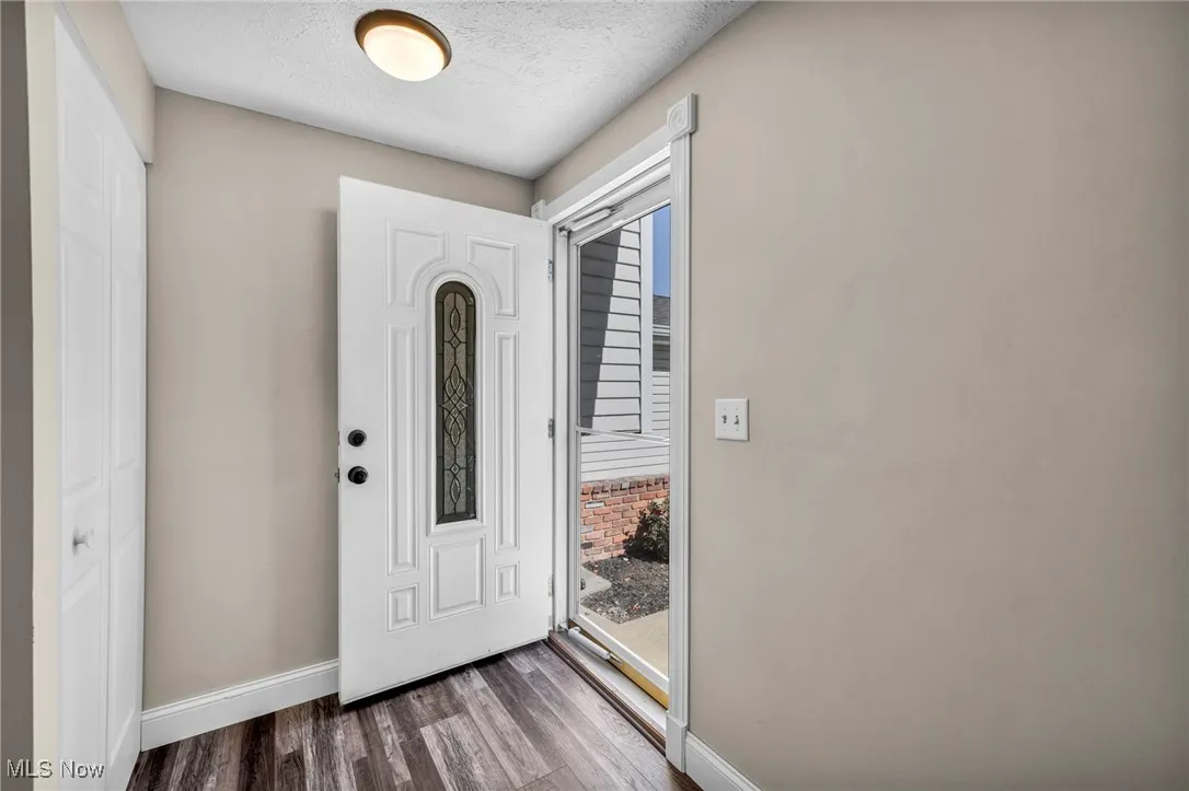 Foyer entrance with wood finished floors and a textured ceiling