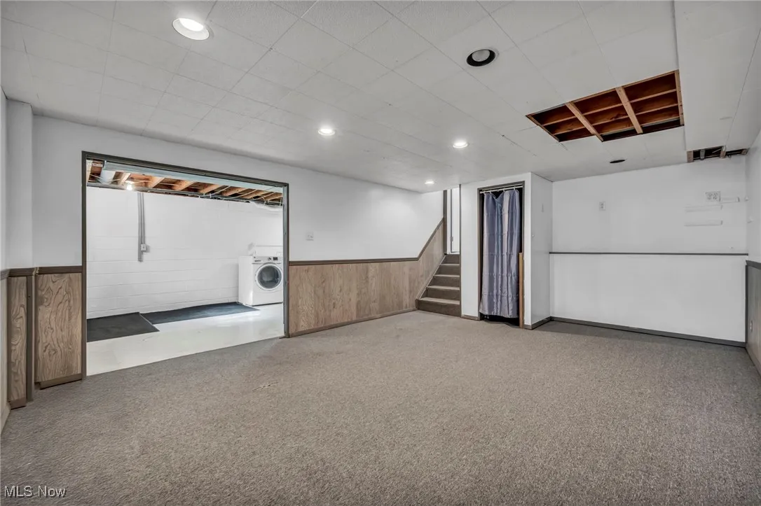 Below grade area with carpet, washer / dryer, stairway, recessed lighting, and wainscoting