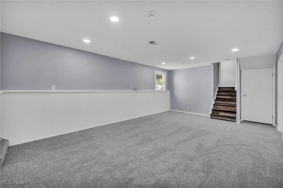 Below grade area featuring stairway, recessed lighting, and carpet flooring