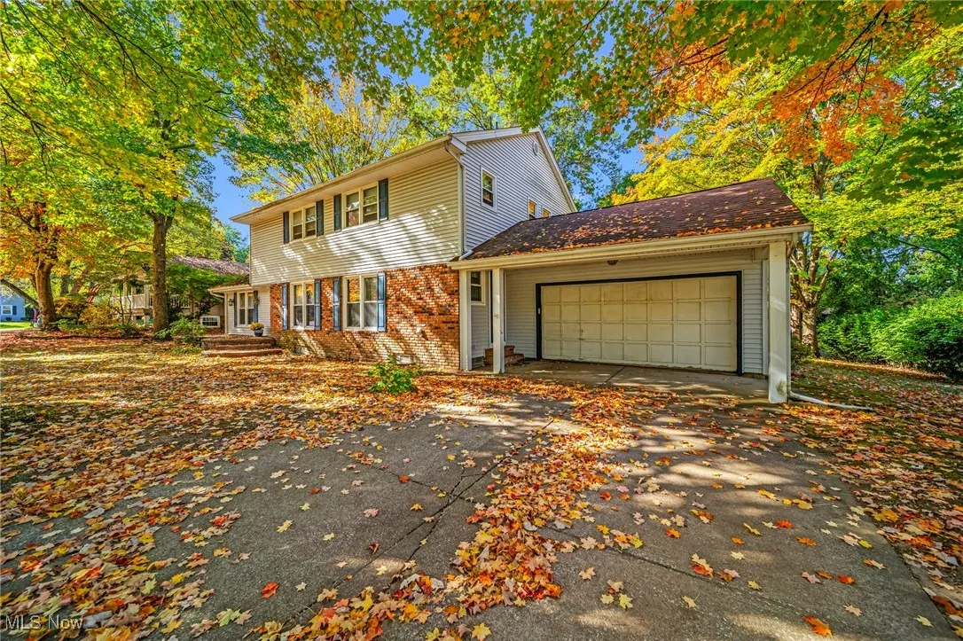 View of front of house with brick siding, a garage, and driveway