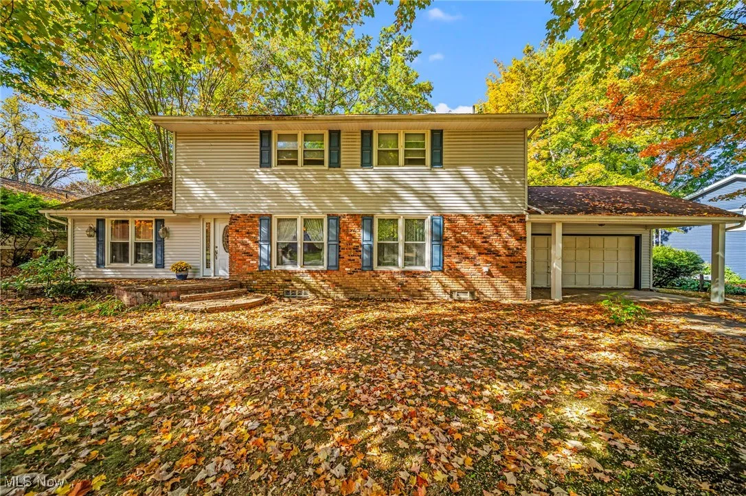 View of front of house with an attached garage and brick siding