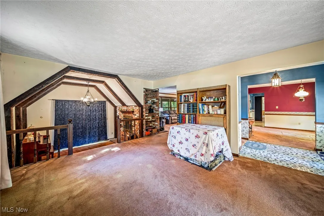 Sitting room with a textured ceiling, a chandelier, and carpet floors