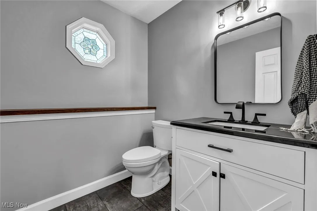 Bathroom featuring vanity and dark tile patterned flooring