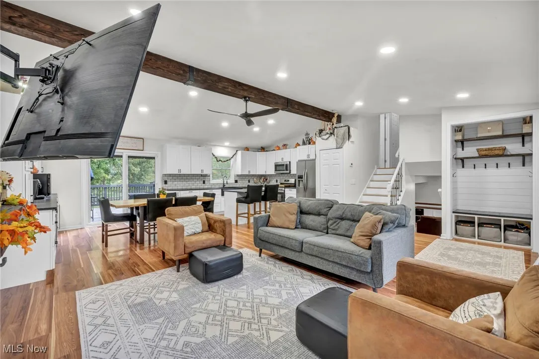 Living room featuring recessed lighting, light wood-type flooring, ceiling fan, and stairs