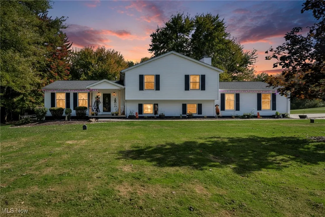 View of front of house featuring a front lawn, a chimney, and covered porch