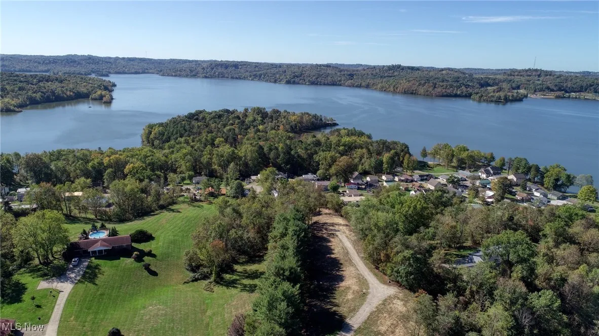Aerial view of property and surrounding area with a forest and Seneca Lake