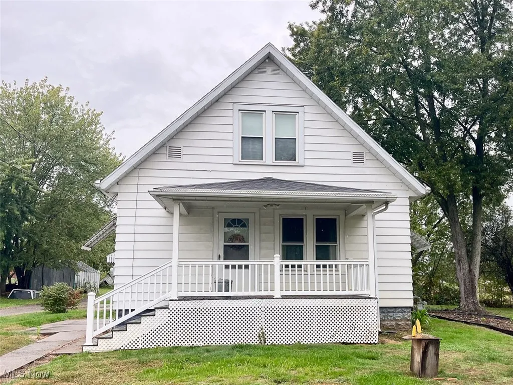 Bungalow featuring covered porch and a front lawn