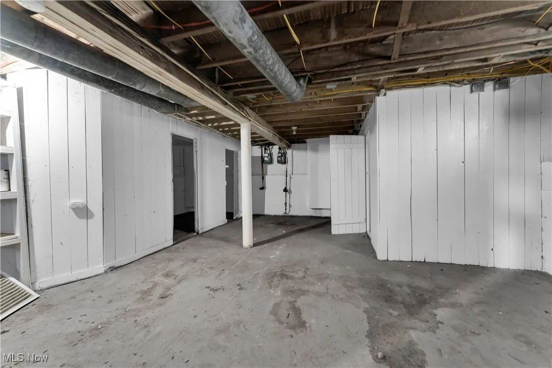 Unfinished basement with wooden walls and gas meter