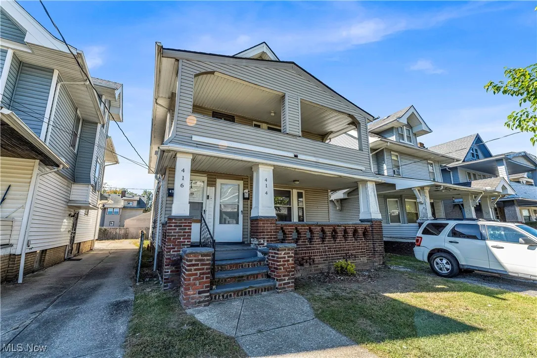 View of front of home featuring a front yard, a balcony, and a porch