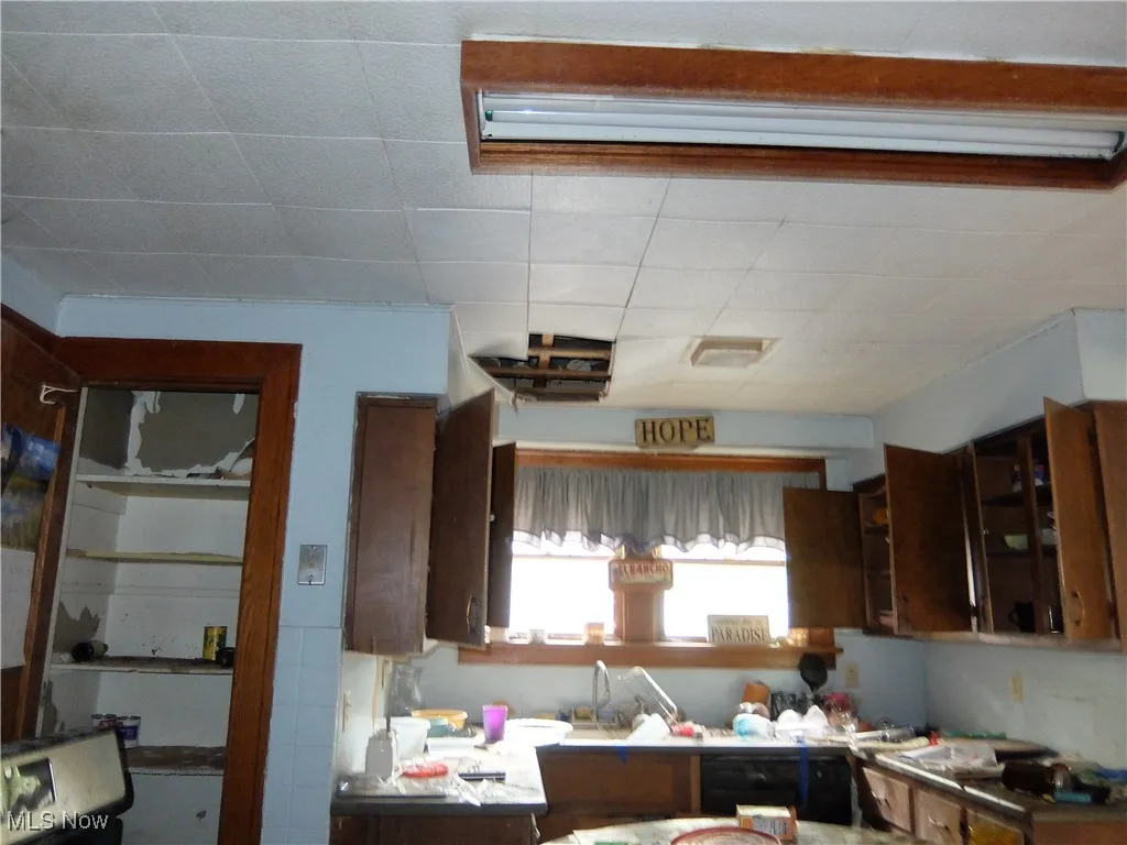Kitchen with dark brown cabinetry and light countertops