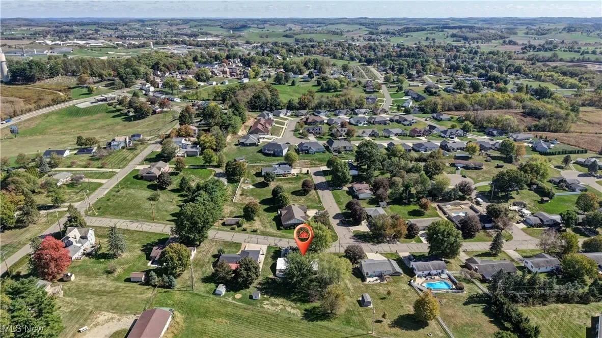Aerial view of property and surrounding area with nearby suburban area