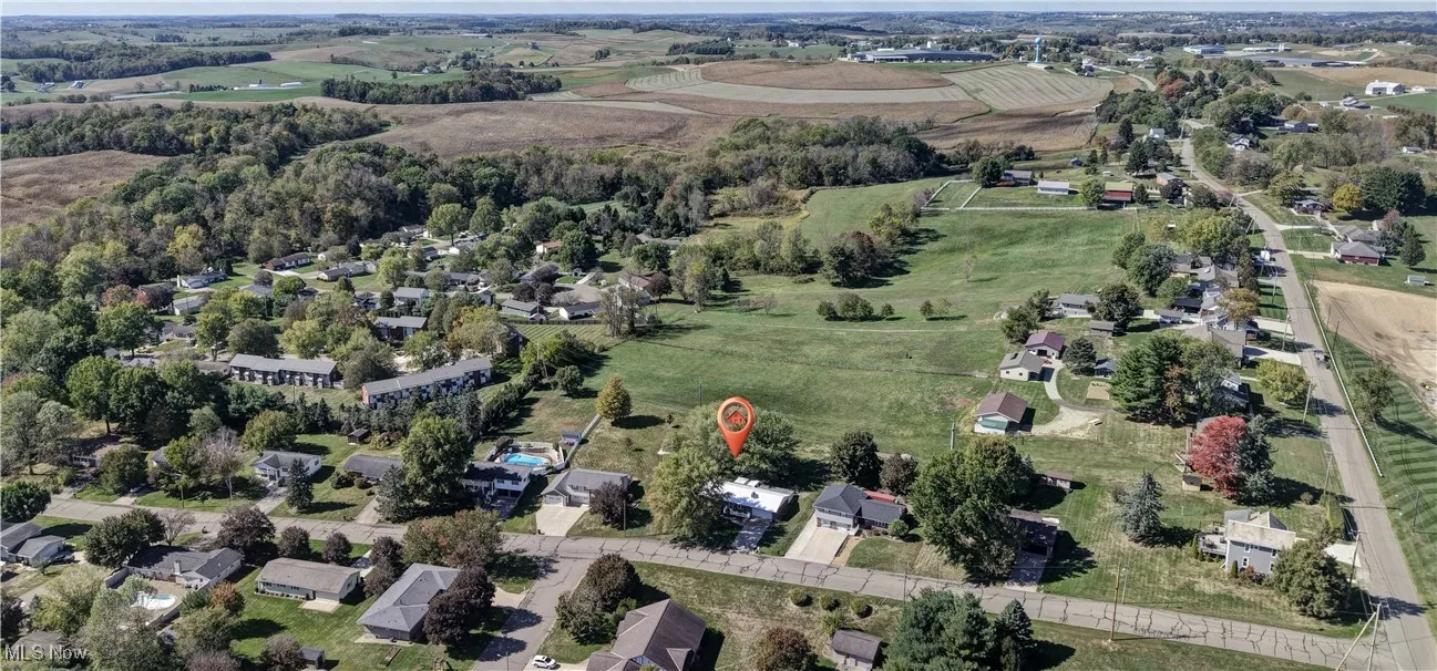 Aerial view of property and surrounding area with nearby suburban area and rural landscape