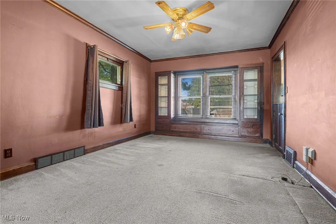 Carpeted spare room with ornamental molding and ceiling fan