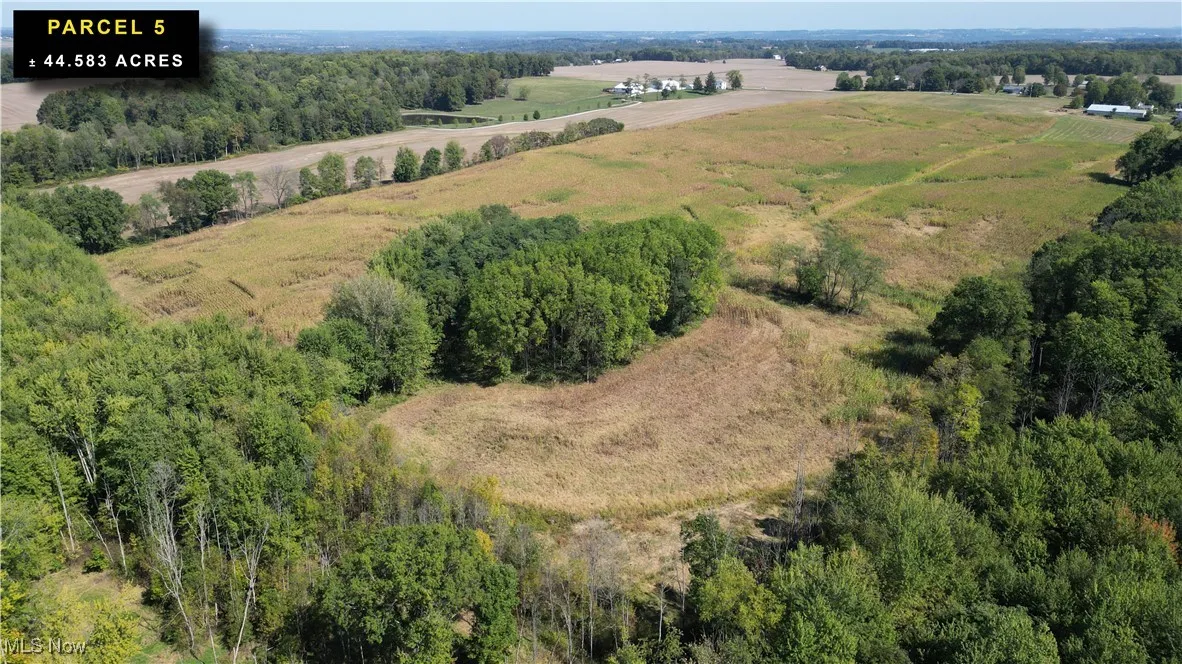 Aerial view of property's location featuring rural landscape and a heavily wooded area