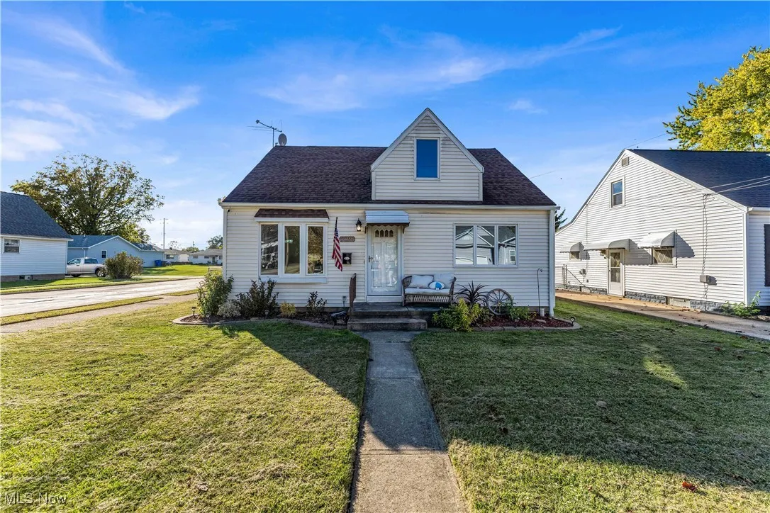 Bungalow featuring a front yard and a shingled roof
