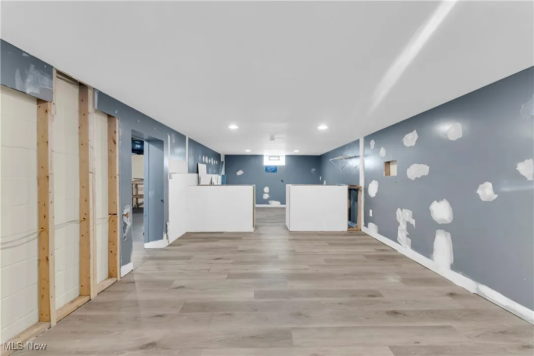 Below grade area with light wood-style flooring and recessed lighting
