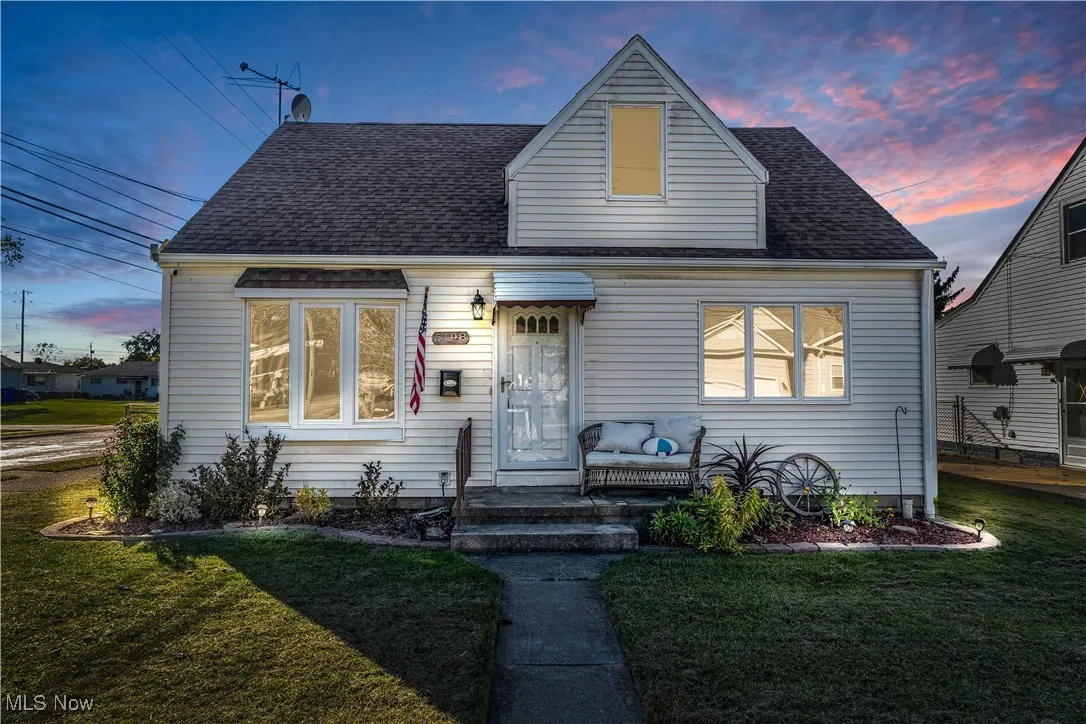 View of front of property featuring a front yard and roof with shingles