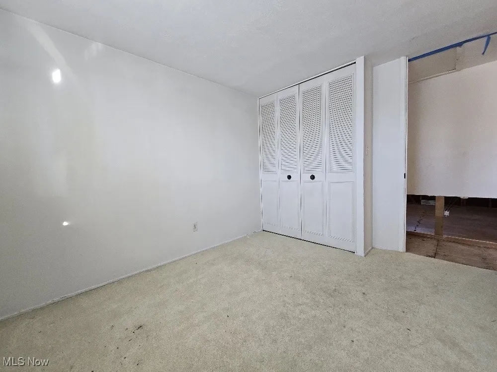 Bedroom with carpet flooring and a closet.