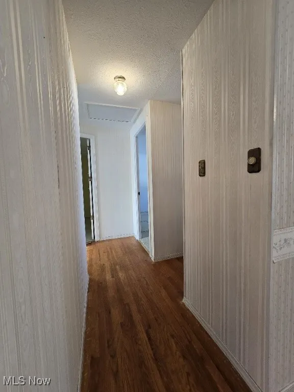 Bedroom Hallway with hard wood finished floors and a textured ceiling.
