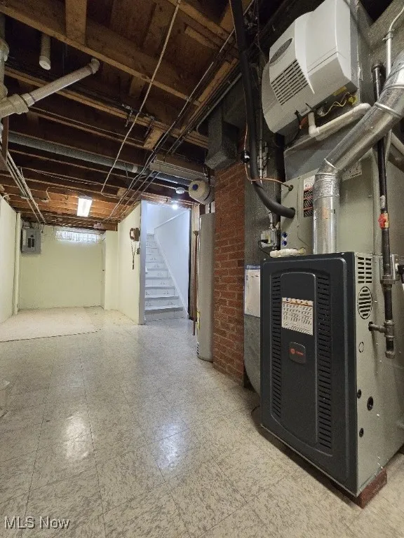 Below grade area featuring tile patterned floors, Trane Furnace, stairway, water heater, and Newer Electric Panel.