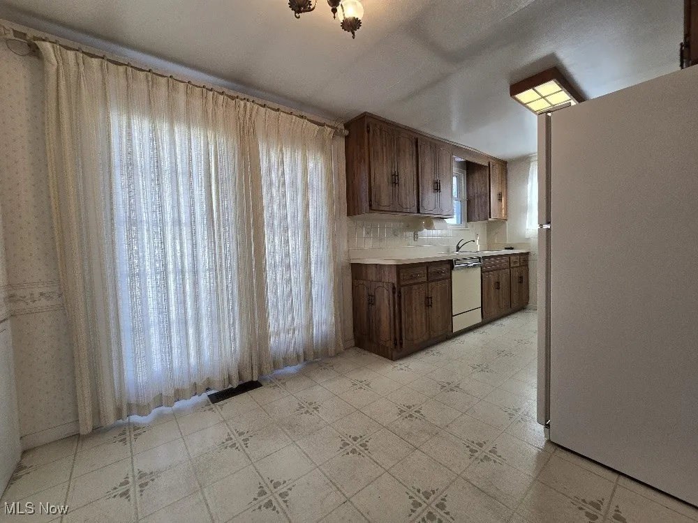 Large Eat-In Kitchen with white appliances, light countertops, decorative backsplash, and Slider to an amazing Back Yard Patio and Fenced Yard!