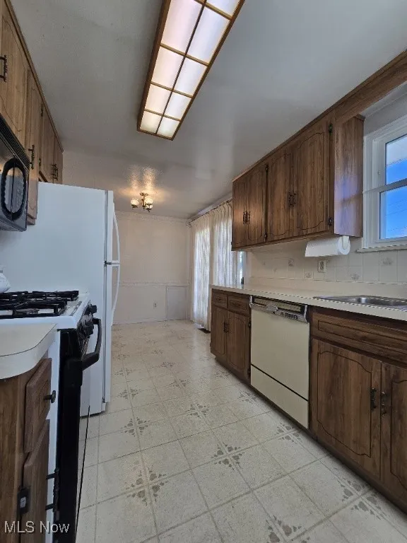 Large Eat-In Kitchen with white appliances, light countertops, decorative backsplash, and Slider to an amazing Back Yard Patio and Fenced Yard!