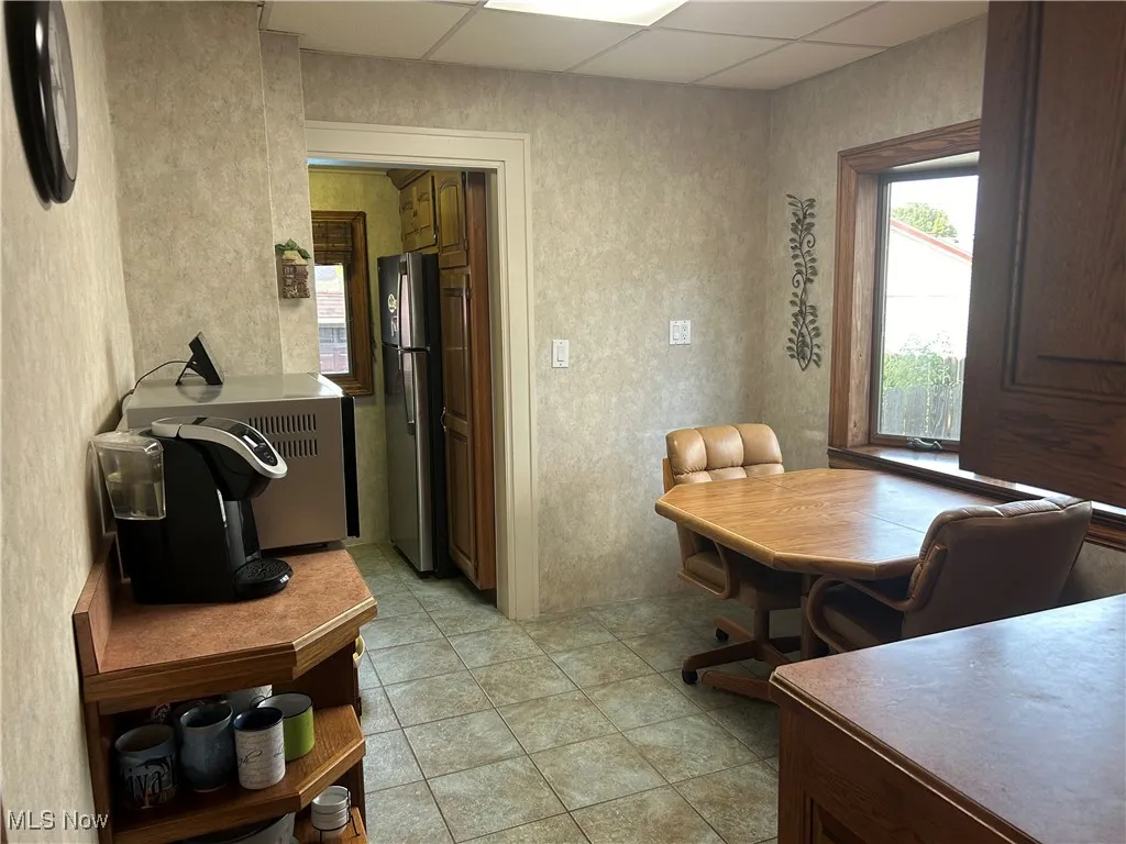 Dining space featuring a paneled ceiling and light tile patterned floors. Large custom-made pantry.