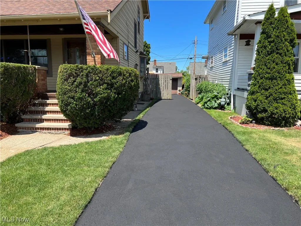 View of side of property with asphalt driveway replaced 2020 and resealed 2025.