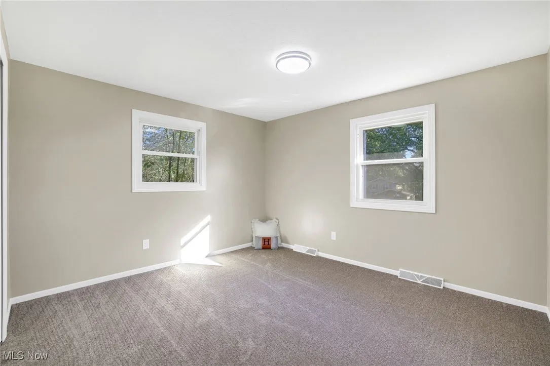 Carpeted empty room featuring plenty of natural light