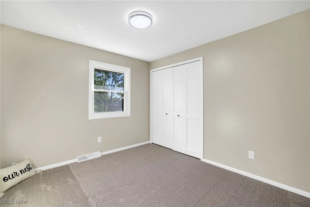 Unfurnished bedroom featuring carpet and a closet