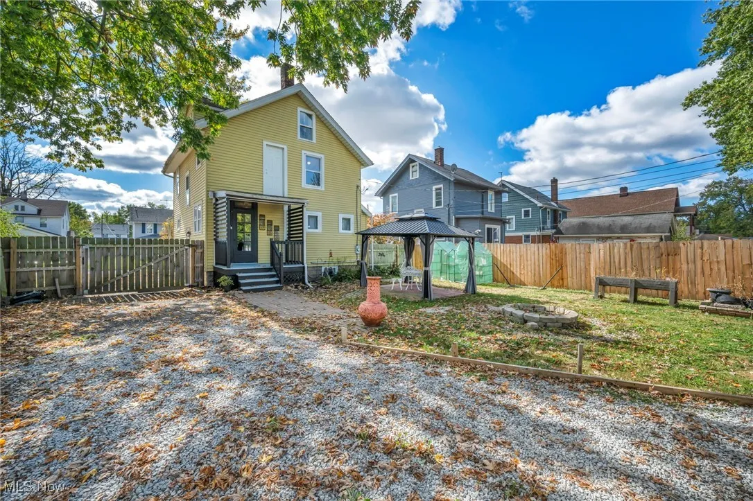 Back of property featuring a fenced backyard, a gazebo, an outdoor fire pit, a patio area, and a residential view