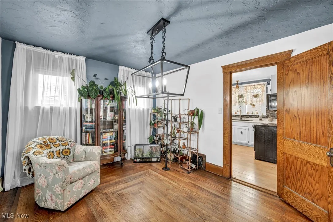 Living area featuring a textured ceiling, parquet floors, and a chandelier