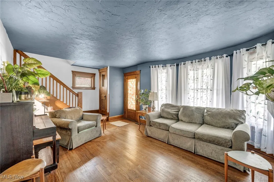 Living area featuring hardwood / wood-style floors, a textured ceiling, and stairway