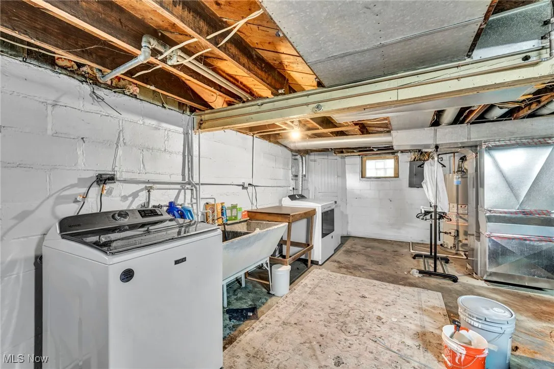 Below grade area with heating unit, washer and clothes dryer, water heater, and electric panel