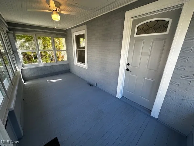 Unfurnished sunroom featuring brick wall and wood finished​​‌​​​​‌​​‌‌​‌‌​​​‌‌​‌​‌​‌​​​‌​​ floors