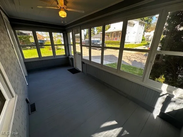 Unfurnished sunroom with a ceiling fan