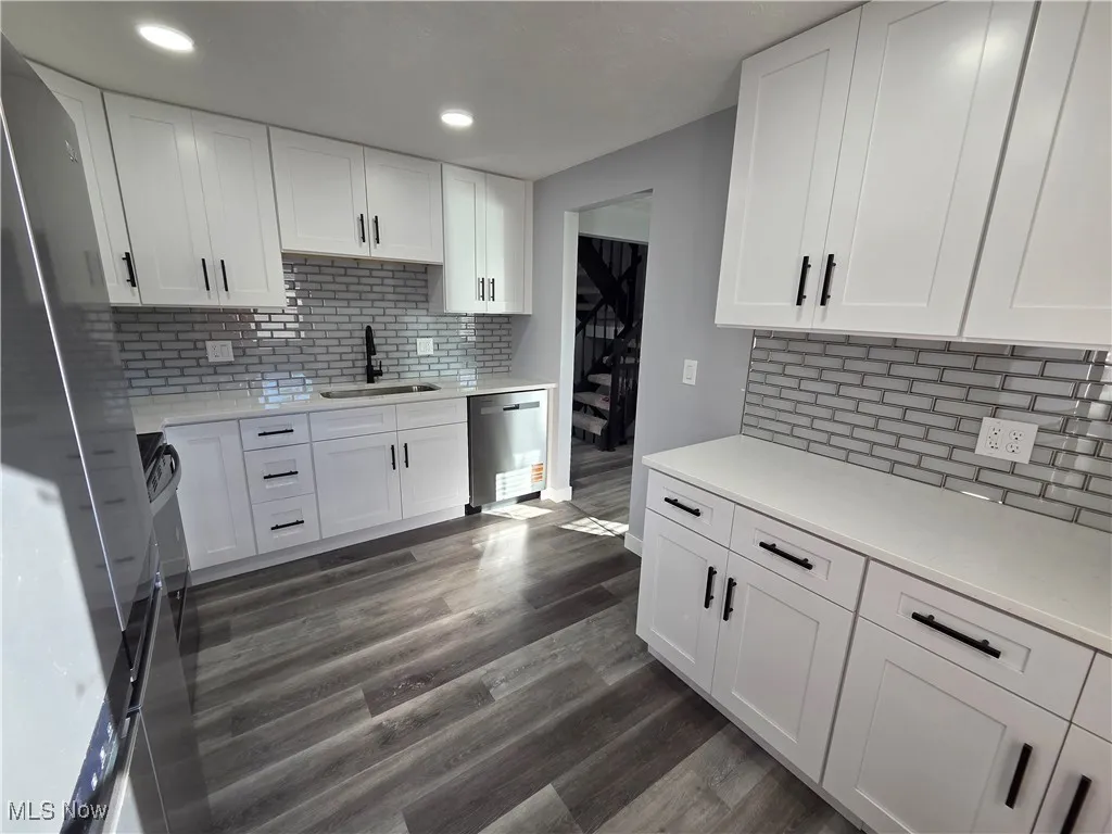 Kitchen featuring stainless steel appliances, white cabinets, quartz countertops, and recessed lighting