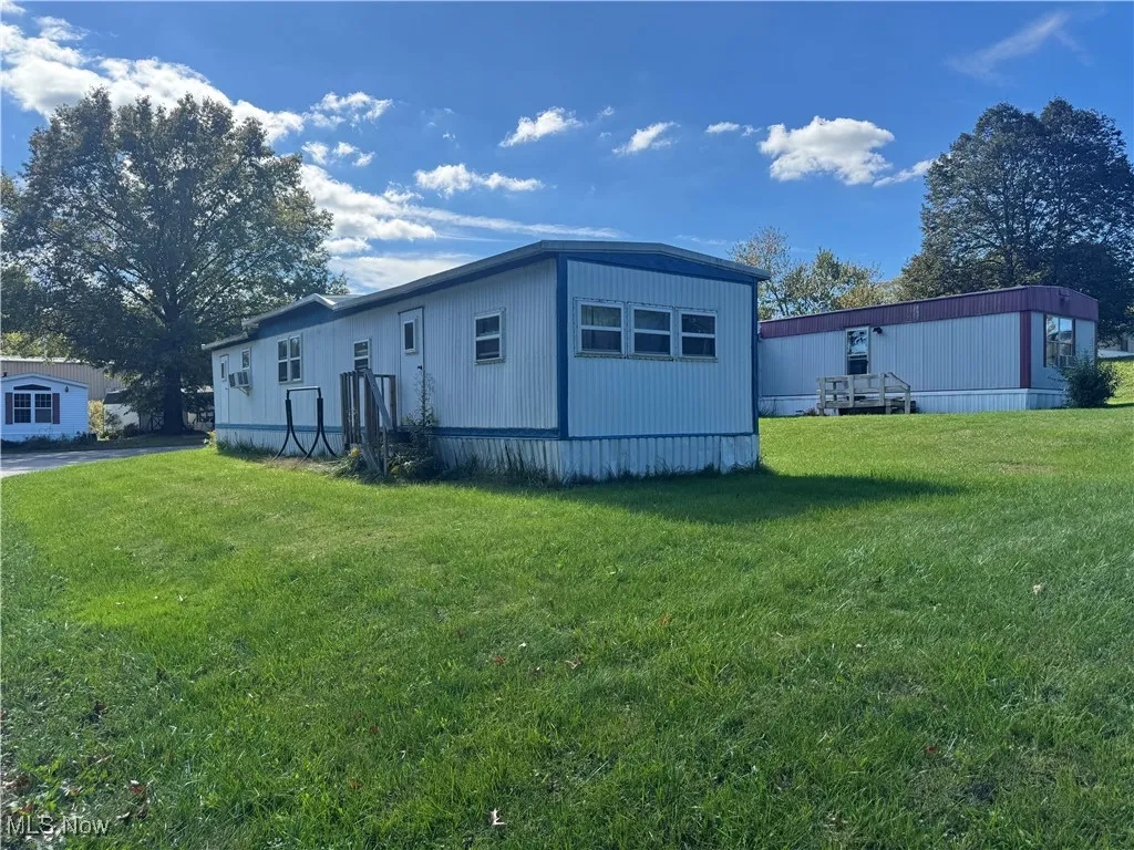 View of side of property featuring a lawn