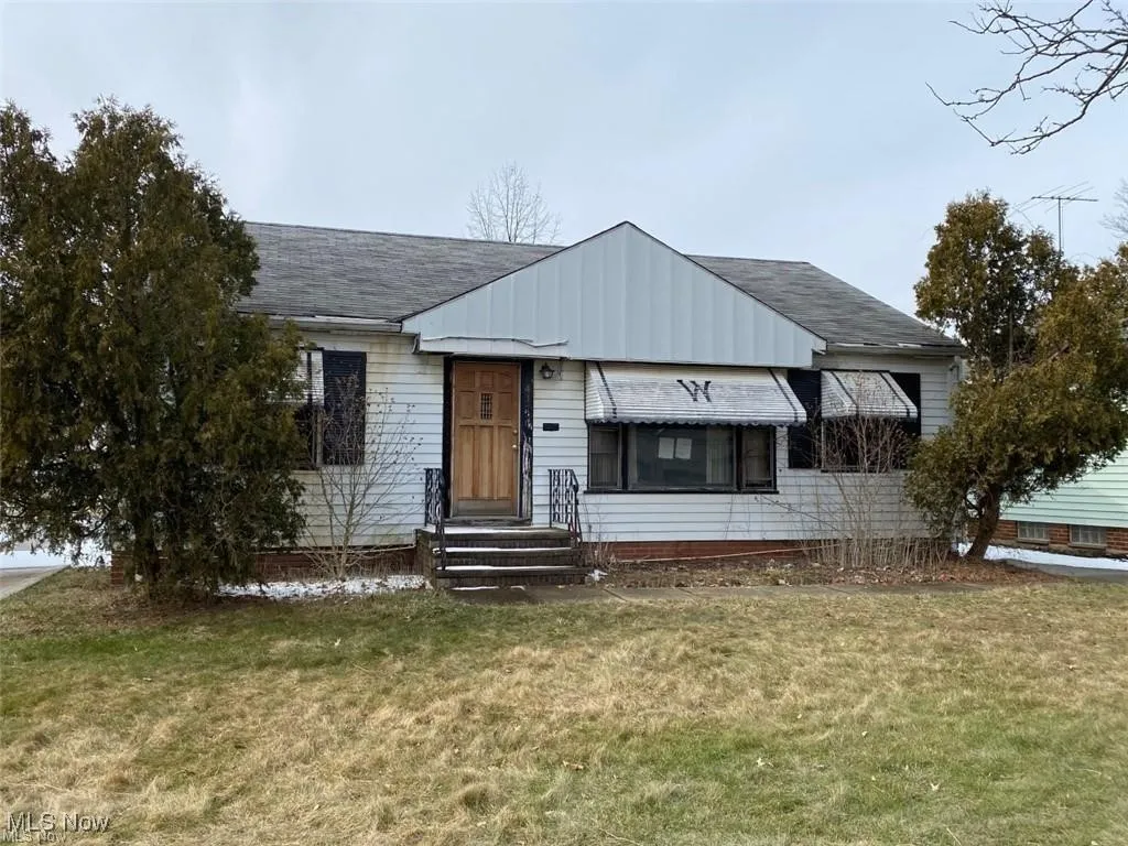 View of front of property with a front yard and roof with shingles