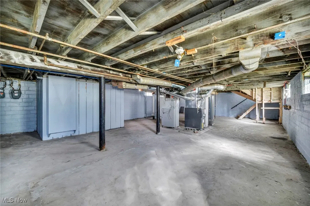 Basement featuring heating unit and water heater